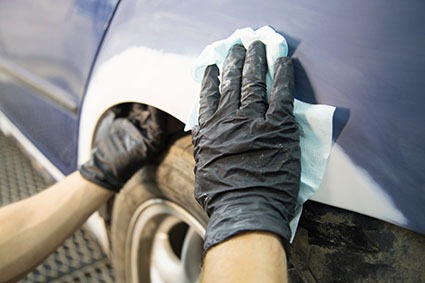 auto repairman plastering autobody bonnet